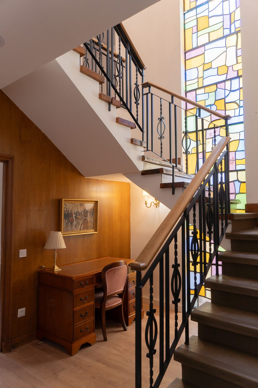 Zona común con escalera y vidriera de colores